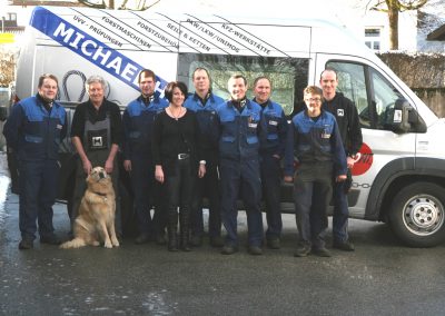 Team (9 Personen mit Hund) vor Transporter