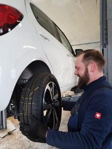 Mechaniker wechselt Reifen in der PKW-Werkstatt