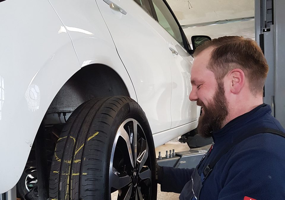 Mechaniker wechselt Reifen in der PKW-Werkstatt